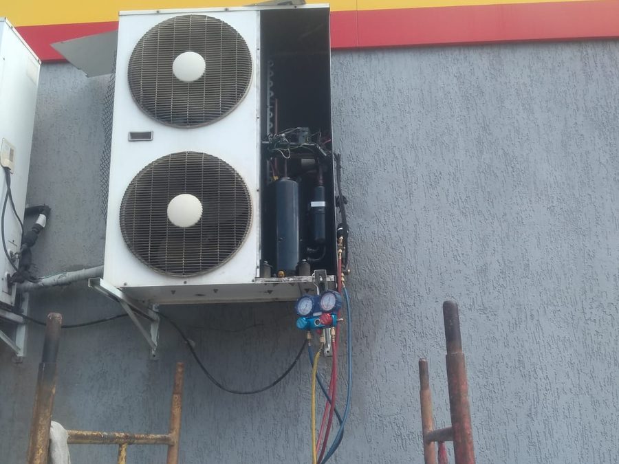 Condensadora de ar condicionado com manifold conectado durante manutenção